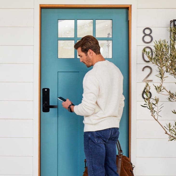 Man using smartphone to open home entrance lock